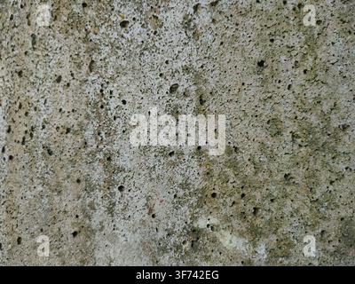 A close up view of porous concrete wall showing numerous tiny holes and a pitted texture. Stock Photo