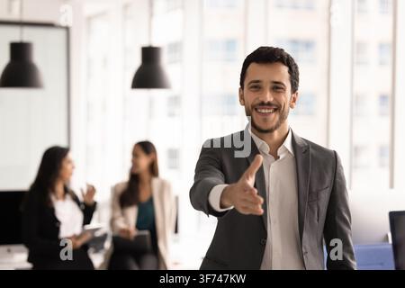 Office portrait of smiling businessman and HR extending hand for welcoming handshake, greeting client or job applicant, represents recruitment, human Stock Photo