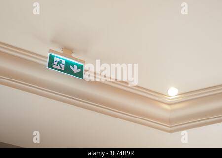Sign for exit direction on ceiling in building Stock Photo