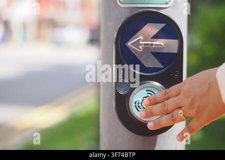 Requesting to cross at a pedestrian signal in the city Stock Photo
