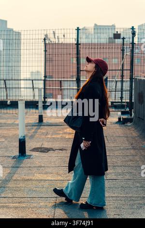 Woman walking with eyes closed on rooftop terrace, Qingdao, China Stock Photo
