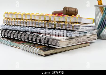Wooden gavel resting on spiral notebooks with colorful school stationery and notes Stock Photo