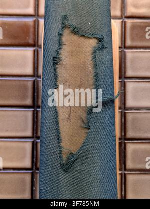 Torn fabric exposed background, in tile wall, with fabric, background, from a close-up perspective, with green, beige accents, and neutral mood, showi Stock Photo