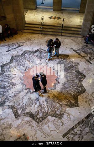 Elevated view of visitors standing on a decorative stone and marble geometric star floor near steps and handrails inside the Royal Ontario Museum, Tor Stock Photo
