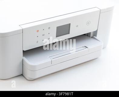 A modern white printer sits on a white surface Stock Photo