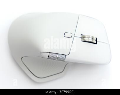 A modern wireless computer mouse rests on a clean white surface Stock Photo