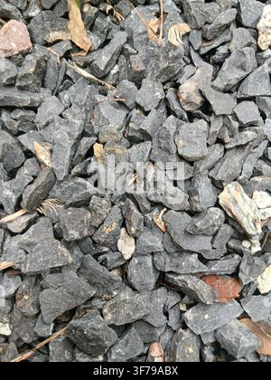 Grey crushed granite gravel and small stones background texture. Top view of clean natural crushed stones, pebbles, and grit for construction. Stock Photo