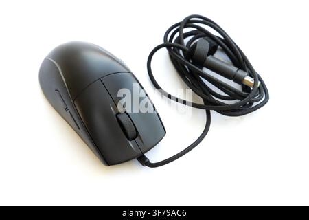 A black wired computer mouse rests on a white background Stock Photo
