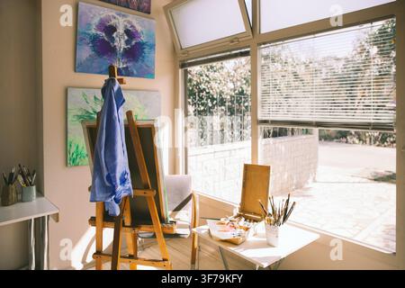 artist studio, art studio interior, creative workspace, artist workspace, painting studio, art supplies, easel, paintings, paintbrushes, brushes. Stock Photo