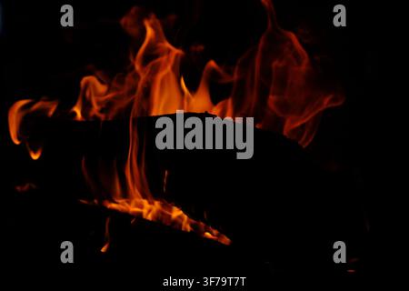 Blazing fire, log burning in a fireplace, orange fire, black background Stock Photo