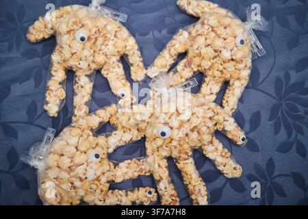Popcorn-filled plastic gloves with googly eyes creating fun monster party treats Stock Photo