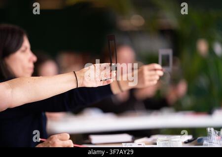 Students use viewfinders to practice composition in an art studio, framing the subject at a painting and drawing class lesson. Stock Photo