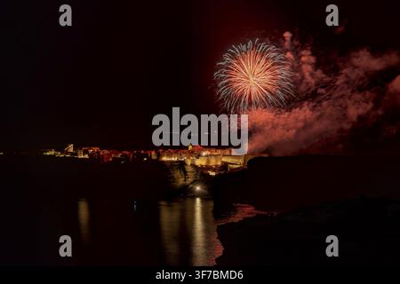Fireworks exploding over the historic fortified city of Bonifacio at night, reflected in the sea, bonifacio, corsica, france Stock Photo