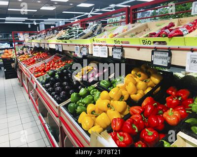 A grocery display with various colorful vegetables including peppers and eggplants, labeled as organic, Paris, France Stock Photo