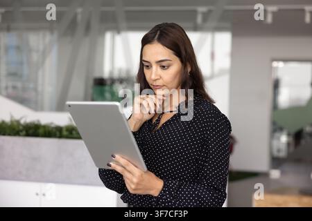 Focused businesswoman analyzing digital data on tablet Stock Photo