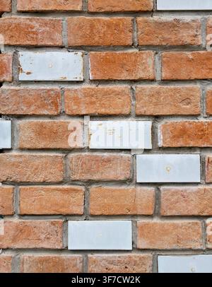 Weathered brick wall with blank white ceramic tiles Stock Photo