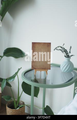 Table with empty canvas and plants in a room Stock Photo