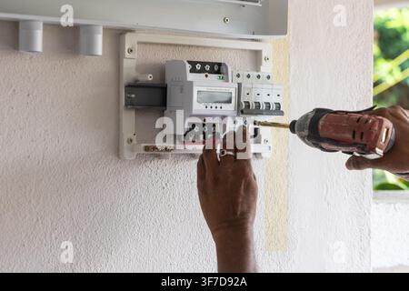Closeup of technician installing solar photovoltaic hybrid inverter into a residential house Stock Photo