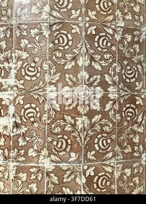 Traditional brown and beige ornate floral Portuguese azulejo tile pattern background texture. Antique vintage ceramic tiles on historic wall in Setuba Stock Photo