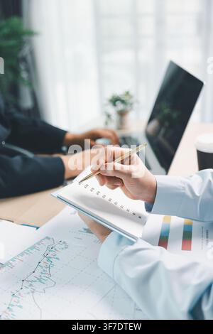 Business team discussing financial dashboard on laptop with charts and reports in office, representing data analysis, digital finance and corporate st Stock Photo