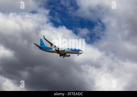 Burgas, Bulgaria - July 23. 2026: TUI passenger airplane flying in the sky through fluffy white and dark clouds, approaching Burgas airport Stock Photo