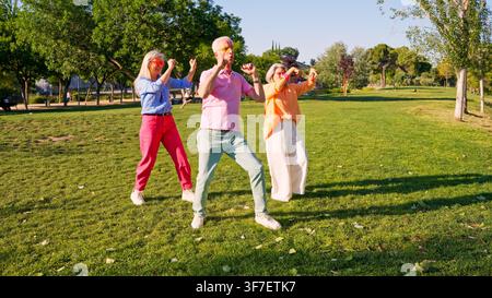 Senior friends enjoying dancing and having fun in park Stock Photo