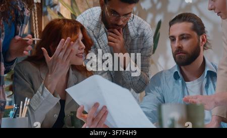 Casual informal business five people arguing discussing building plan blueprint paper document argue talking men women team at work conference Stock Photo