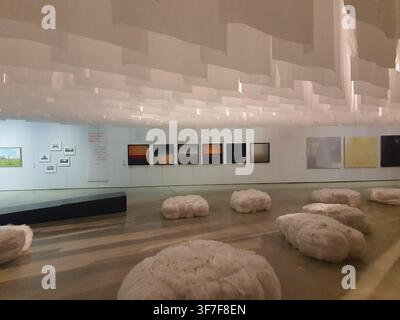 Interior view of a contemporary art gallery or museum exhibition space featuring minimalist design. The room has white walls displaying various Stock Photo