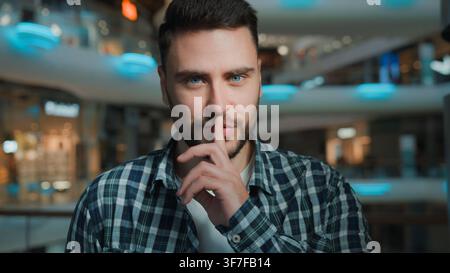 Portrait confident Caucasian man looking at camera showing hush silence gesture with index finger business male businessman European guy client Stock Photo