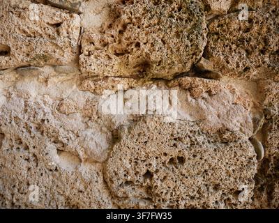 Detailed rough stone wall texture background with natural earthy colors, weathered rock surface, and organic patterns for modern architectural design Stock Photo