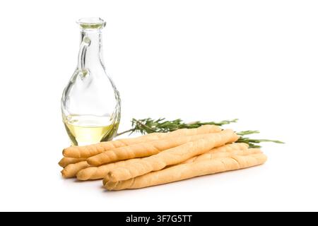 Crisp Italian breadsticks (grissini) arranged with a glass cruet of olive oil and fresh rosemary on a white background, ideal for appetizer, snack, re Stock Photo