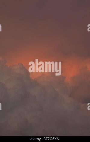Dramatic storm clouds illuminated by warm sunset light Stock Photo