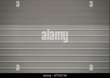 Commercial close-up shot of modern horizontal window blinds with a subtle texture. This minimalist architectural element is ideal for interior design mockups, home decor concepts, window treatment catalogs, and contemporary background solutions. Stock Photo