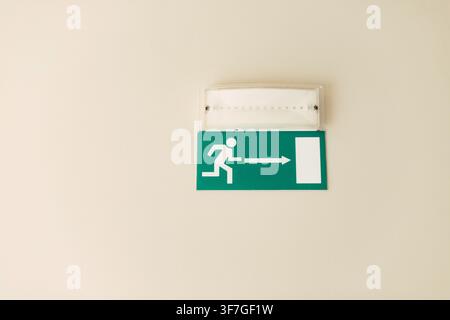 Green emergency exit sign on the ceiling Stock Photo
