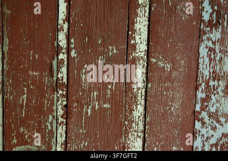 Old wooden boards with peeling white and brown paint creating a rough grunge texture background. Stock Photo