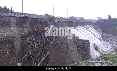 Concrete dam structure with water cascading over the wall spillway concrete Stock Photo