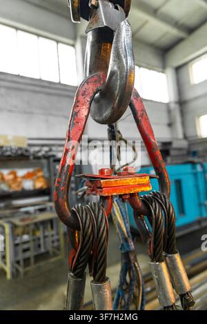Heavy duty crane hook with wire rope slings in industrial workshop Stock Photo