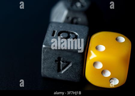 Two game dice close up showing contrast of color and number style on dark table Stock Photo
