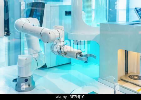 Industrial robotic arm operating advanced automation equipment in Shenzhen, China. Robotic automation, artificial intelligence, smart manufacturing Stock Photo