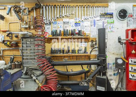 Parts drawers, various hand tools including wrenches, screwdrivers, hammer arranged on shelves and hanging rack inside home garage workshop, Quebec, C Stock Photo
