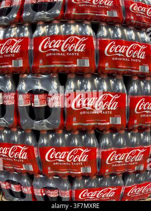 Perspective dynamically deformed photo of stacked 0.5 liter PET bottles recyclable plastic containers polyethylene terephthalate with caffeinated suga Stock Photo