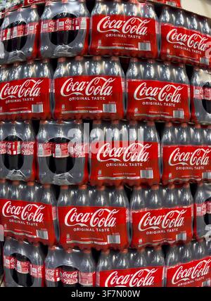 Perspective dynamically deformed photo of stacked 0.5 liter PET bottles recyclable plastic containers polyethylene terephthalate with sugary caffeinat Stock Photo