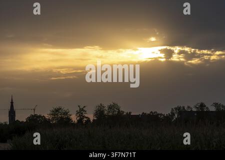 Stuttgart, Germany, August 3, 2026: Sunset with a dramatic backdrop of clouds in the vicinity of Stuttgart Airport. Golden rays of light fall on the l Stock Photo
