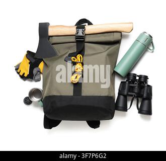 Camping backpack with axe, binoculars, thermos, gloves, and compass for outdoor adventure, isolated on white background Stock Photo