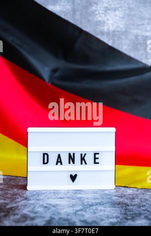 Lightbox with text DANKE THANK YOU National symbol of Germany. German wave silky flag background. Concept of thanksgiving day and gratitude  Stock Photo