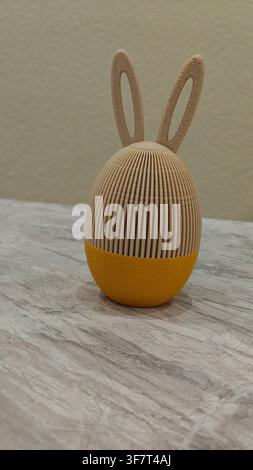 Yellow 3D-printed Easter egg with textured bunny ears, a creative holiday decoration and unique gift idea Stock Photo