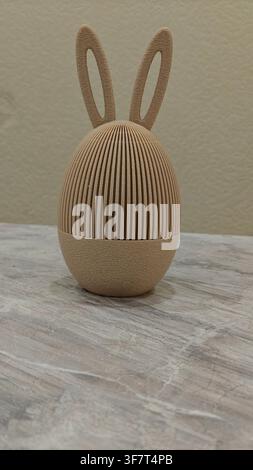 Beige 3D-printed Easter egg with textured bunny ears, a creative holiday decoration and unique gift idea Stock Photo