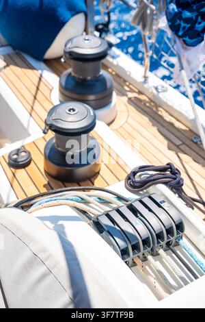 Sailboat winches and rope clutches on the deck of a modern sailing yacht. Professional sailing equipment for sail handling and boat control. Stock Photo