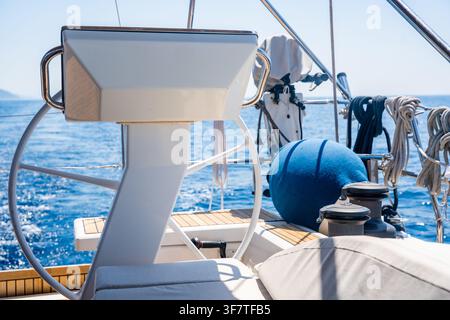 View of the helm station, steering wheel and cockpit of a modern sailing yacht cruising on the open sea. Concept of yacht navigation, sailing Stock Photo