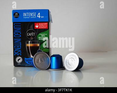 Vilshofen, Germany. 09th Aug, 2026. Three blue metallic coffee capsules placed in front of a blue Cafèt Lungo Intense coffee capsule box on a white reflective surface. (Photo by Igor Golovniov/SOPA Images/Sipa USA) Credit: Sipa USA/Ģ����ý Live News Stock Photo